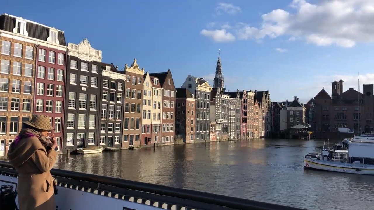 Old gabled houses on Damrak above the water in Amsterdam, filmed by TravelHub
