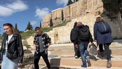 Visitors climbing the steps up the slope of the Acropolis in Athens