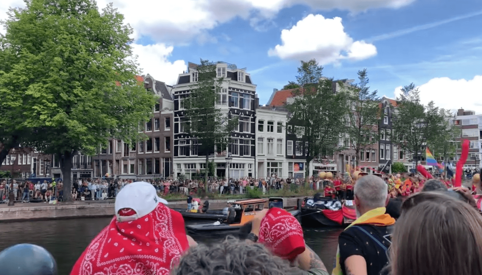 Crowds along an Amsterdam canal watching the Pride Canal Parade