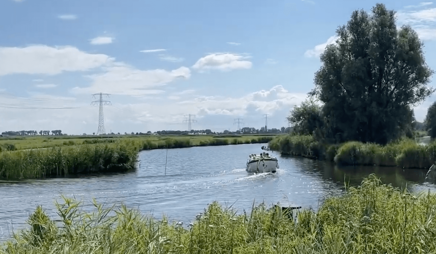 A small boat on a canal through the Landsmeer polder countryside