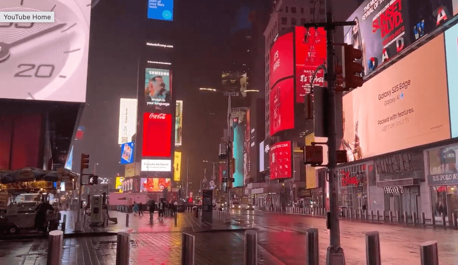 A quiet, rain-slicked Times Square at night on an ordinary evening
